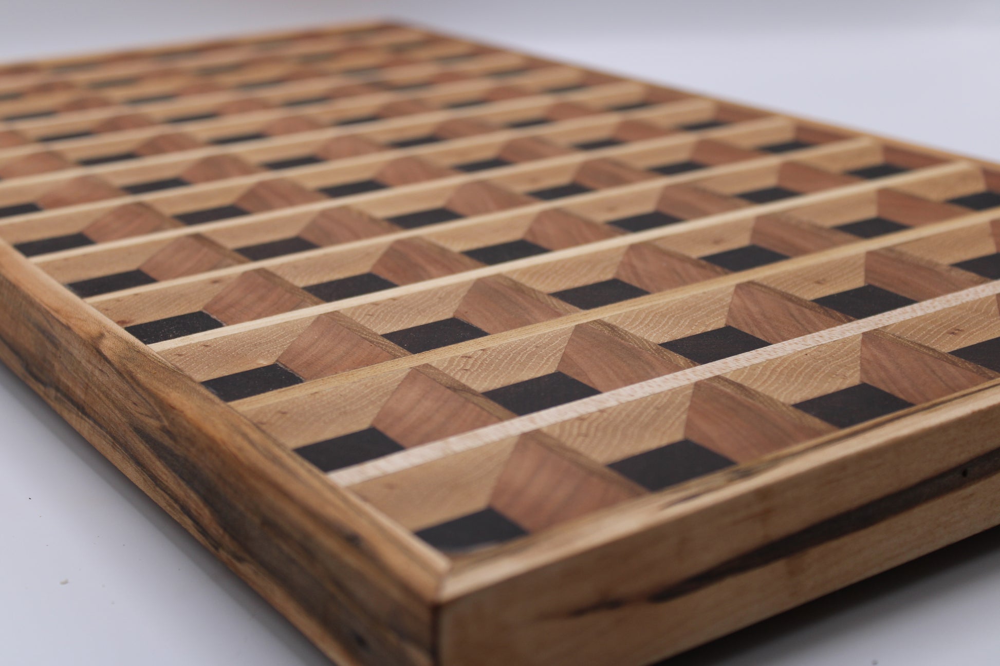Wooden cutting board with a 3-D geometric pattern on a white background