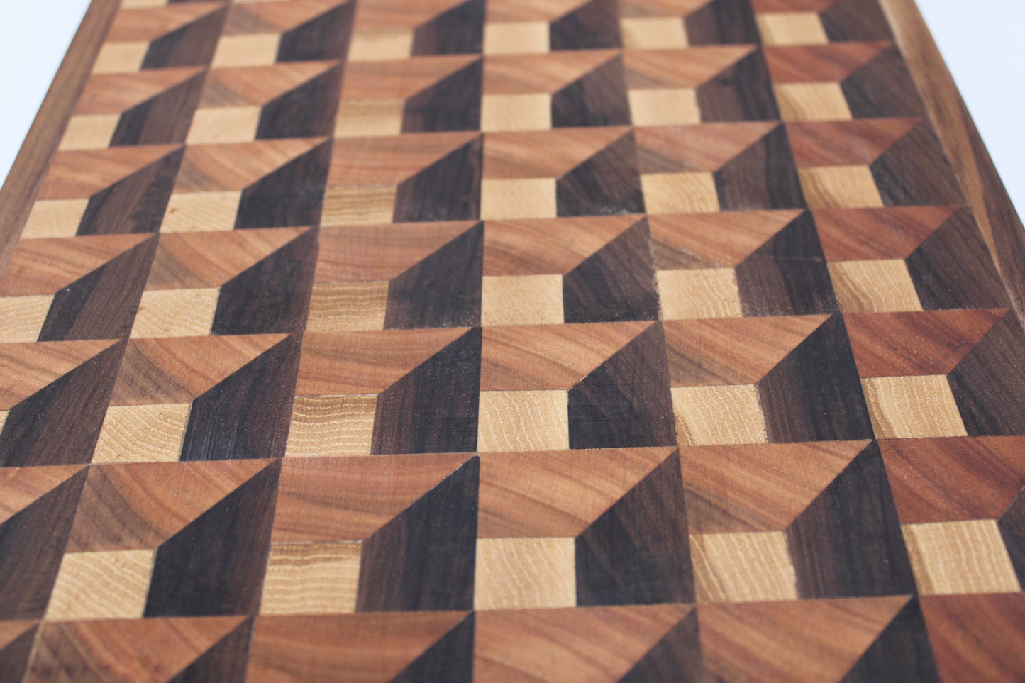 Wooden cutting board with a 3-D geometric pattern on a white background
