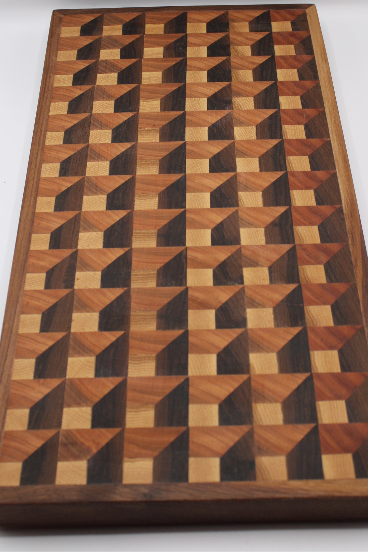 Wooden cutting board with a 3-D geometric pattern on a white background