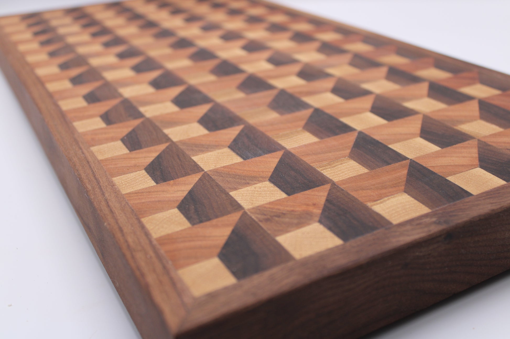 Wooden cutting board with a 3-D geometric pattern on a white background