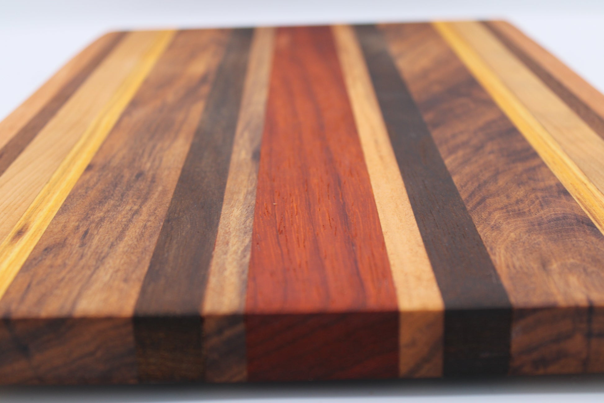 Wooden cutting board with multicolored stripes on a white background