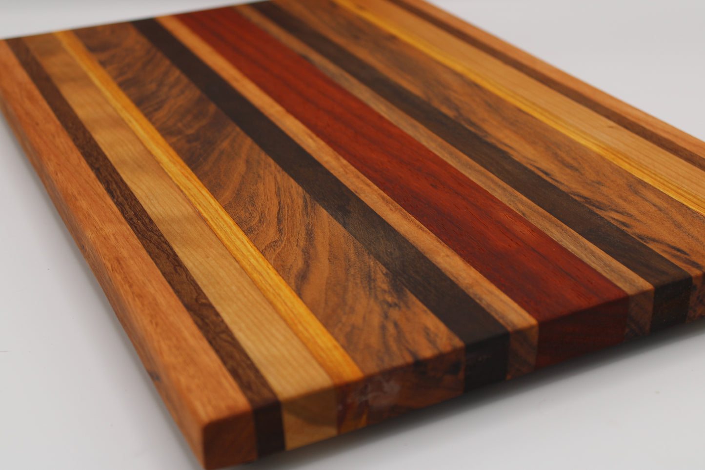 Wooden cutting board with multicolored stripes on a white background