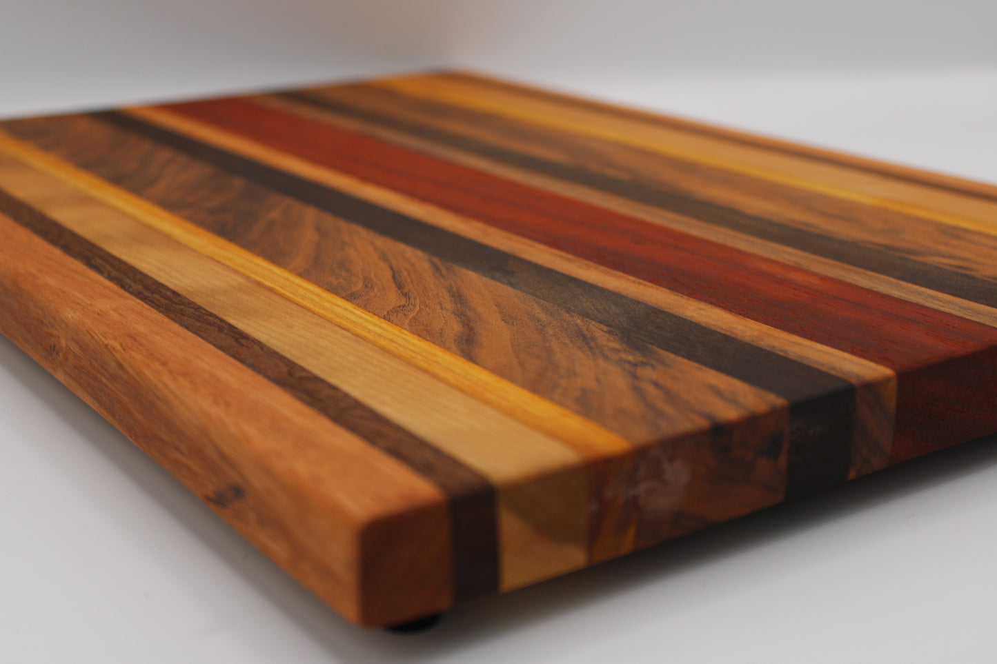 Wooden cutting board with multicolored stripes on a white background