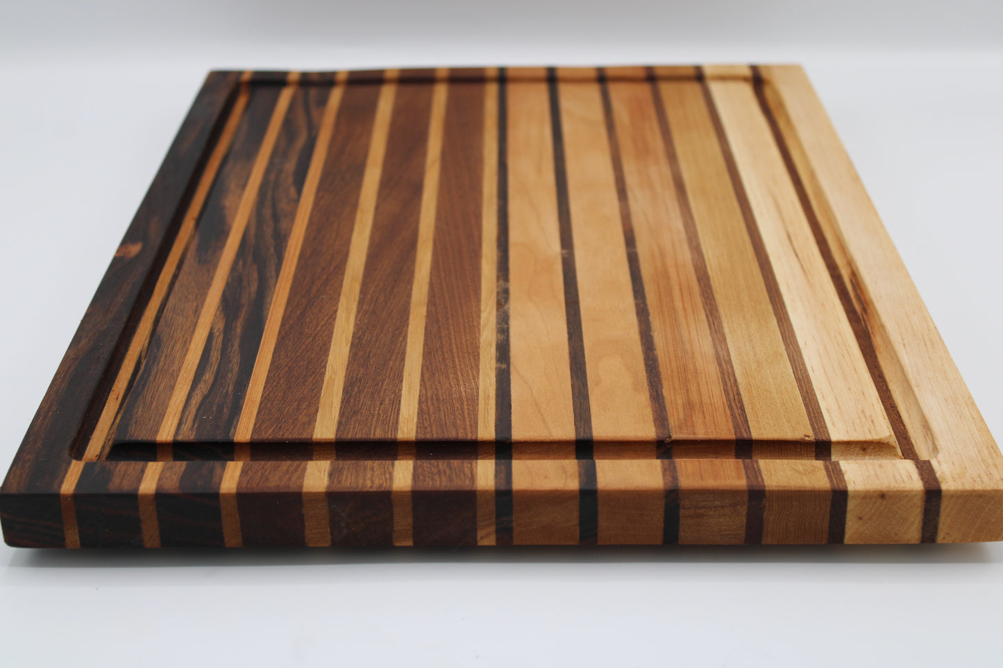 Wooden cutting board with striped pattern on a white background