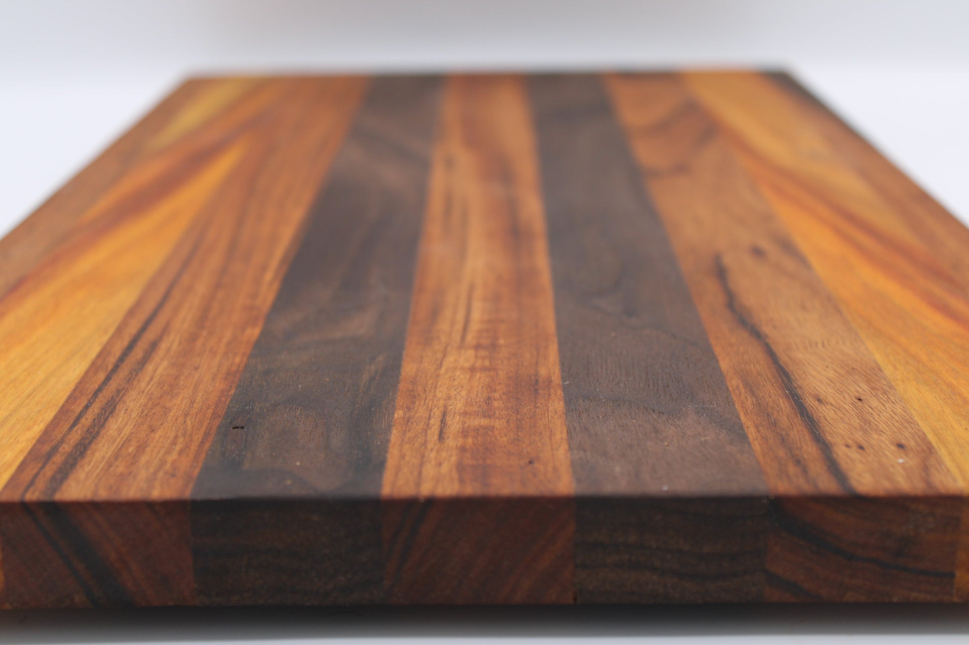 Wooden cutting board with a striped pattern on a white background