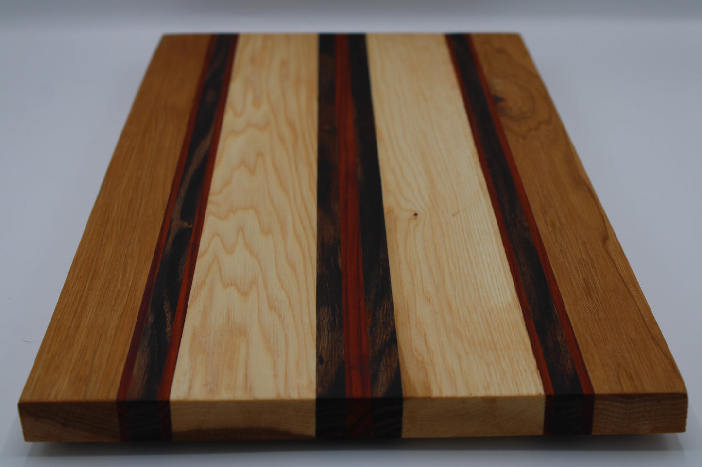 Wooden cutting board with multicolored stripes on a white background