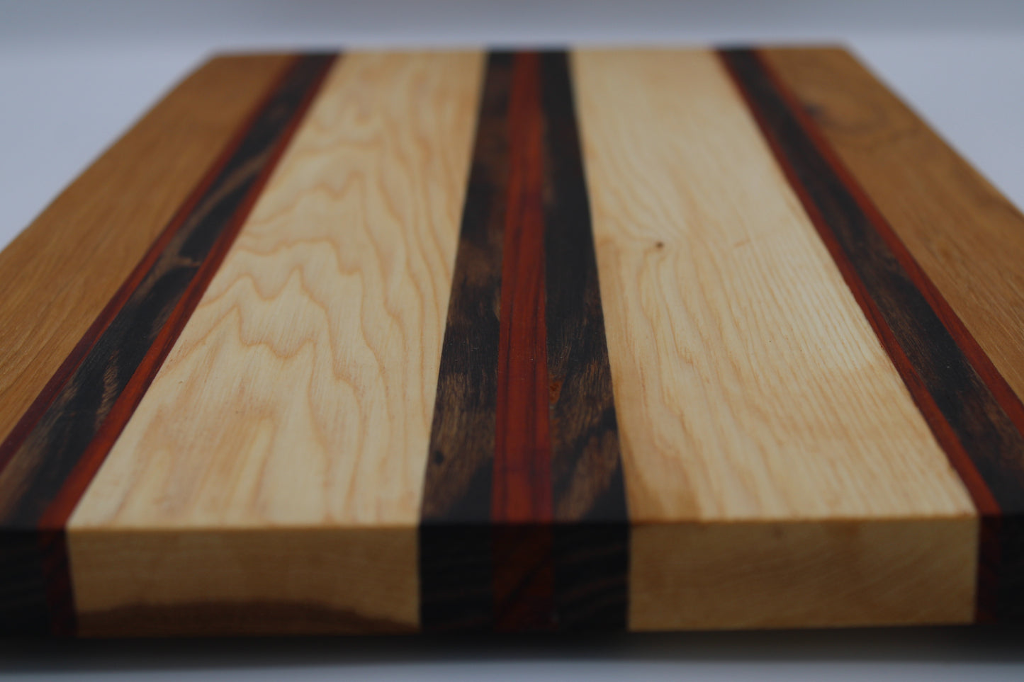 Wooden cutting board with multicolored stripes on a white background