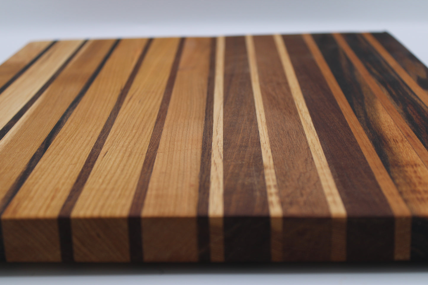 Wooden cutting board with striped pattern on a white background