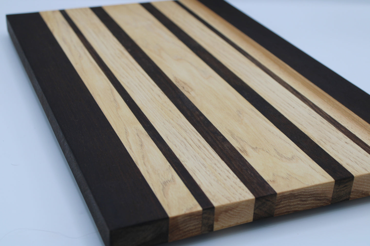 Wooden cutting board with black and brown stripes on a white background
