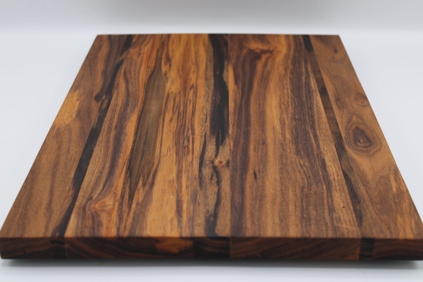 Wooden cutting board with a visible grain pattern on a white background