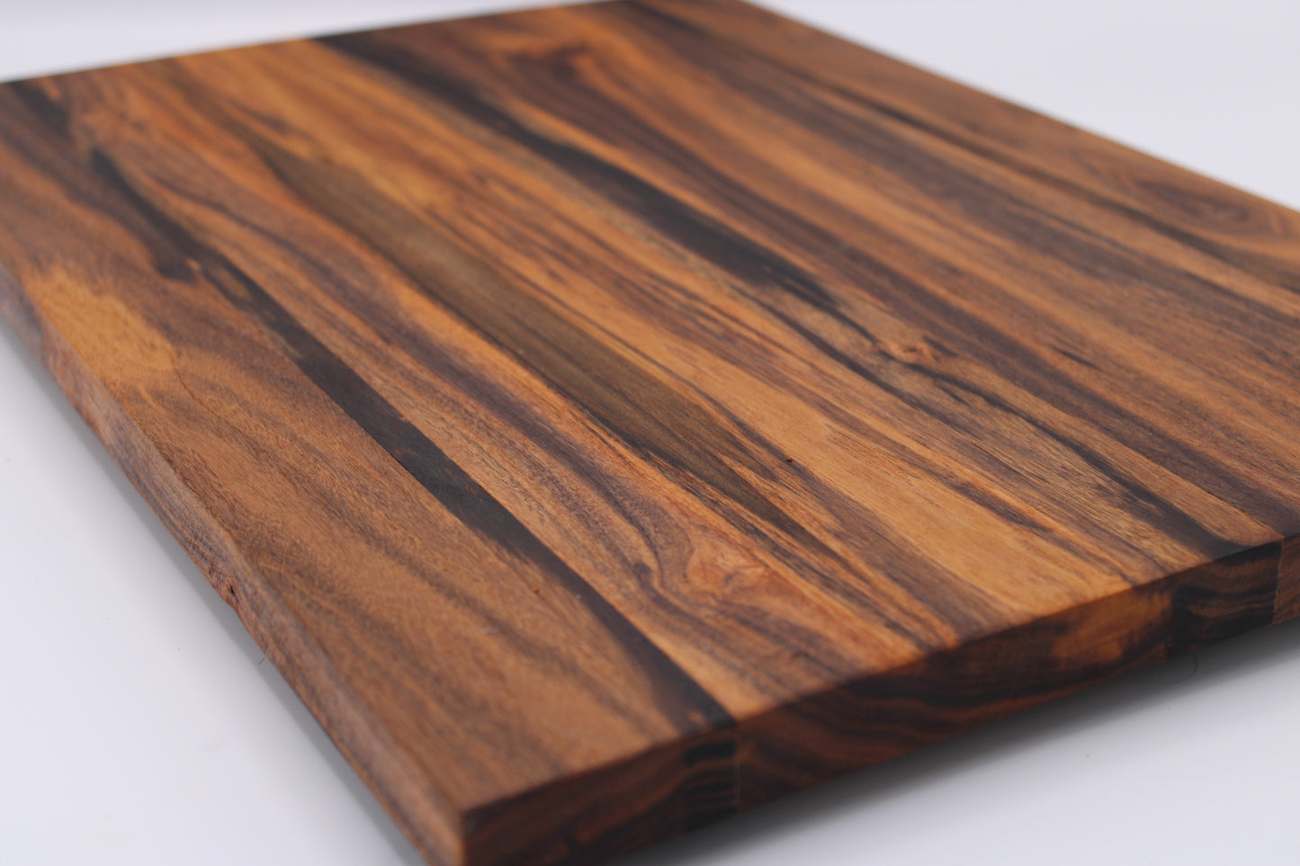 Wooden cutting board with a striped pattern on a white background