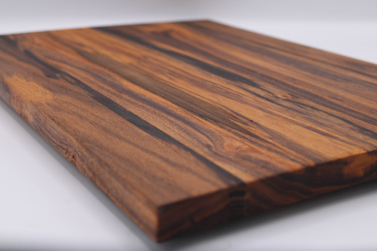 Wooden cutting board with a striped pattern on a white background