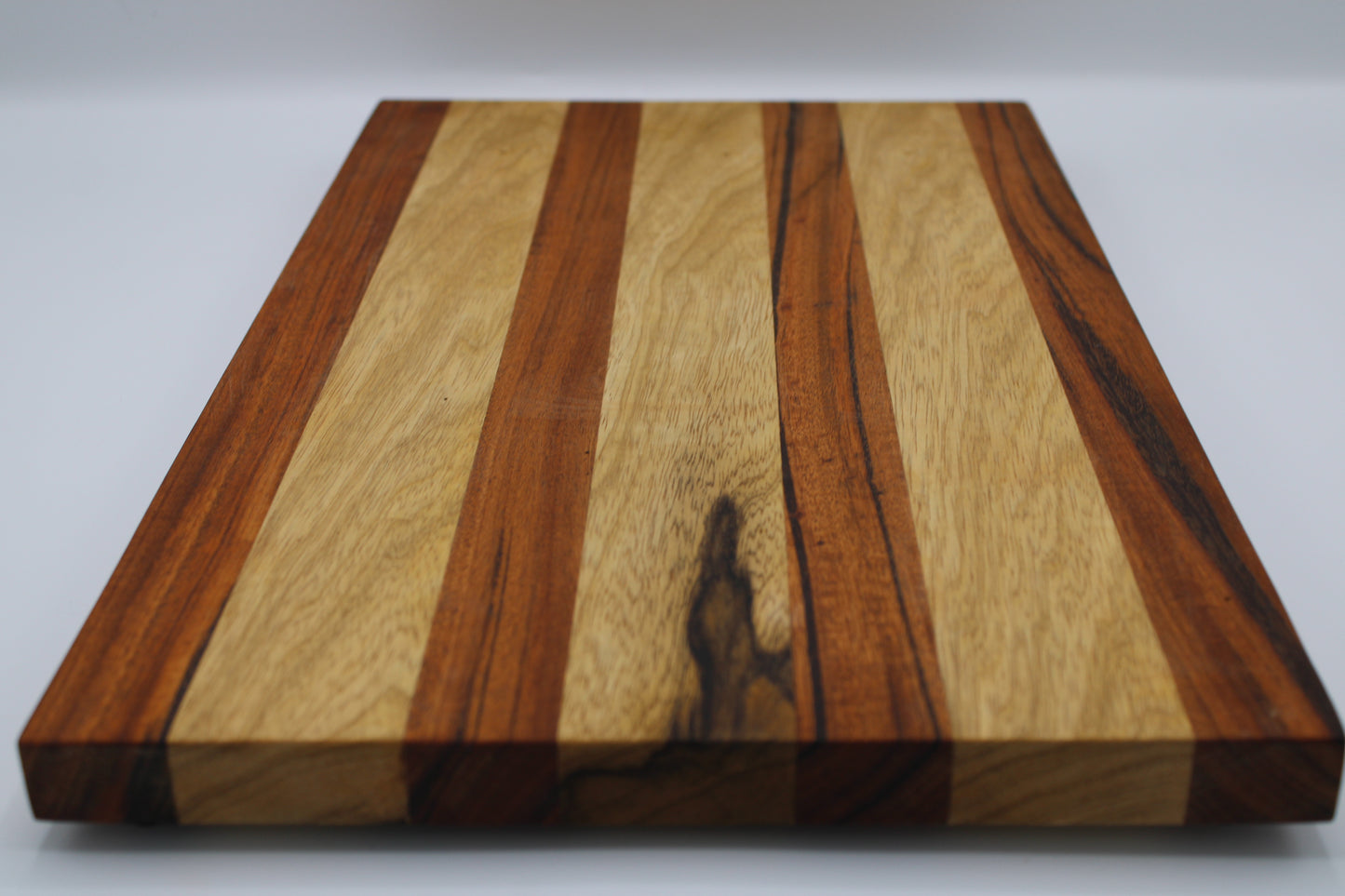 Wooden cutting board with striped pattern on a white background