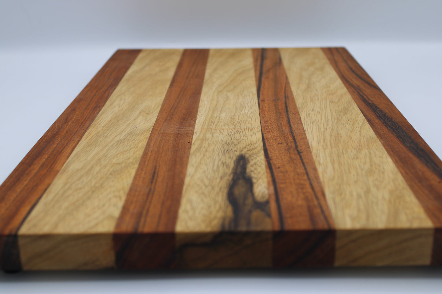 Wooden cutting board with a striped pattern on a white background
