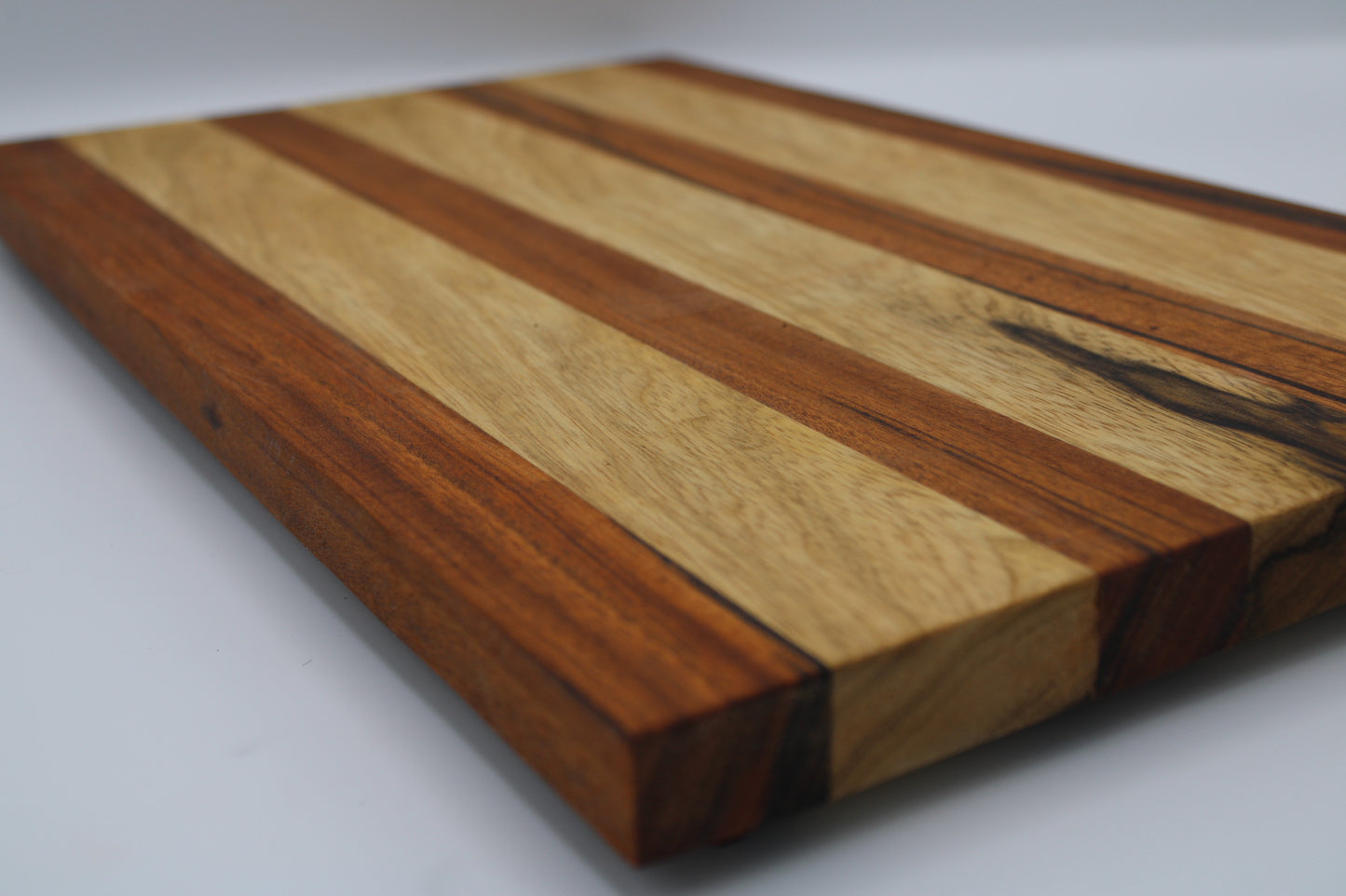 Wooden cutting board with striped pattern on a white background