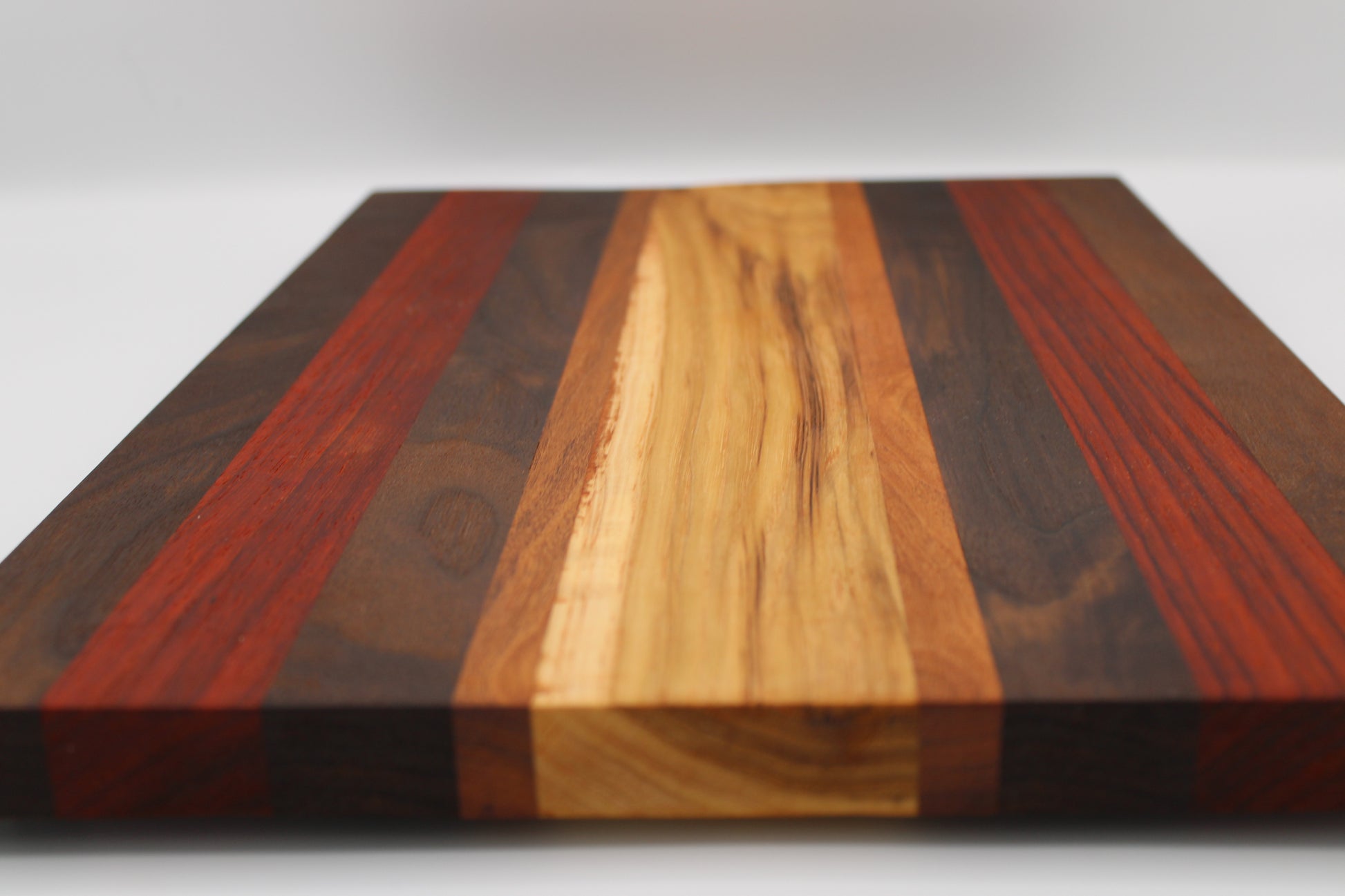 Wooden cutting board with multicolored stripes on a white background