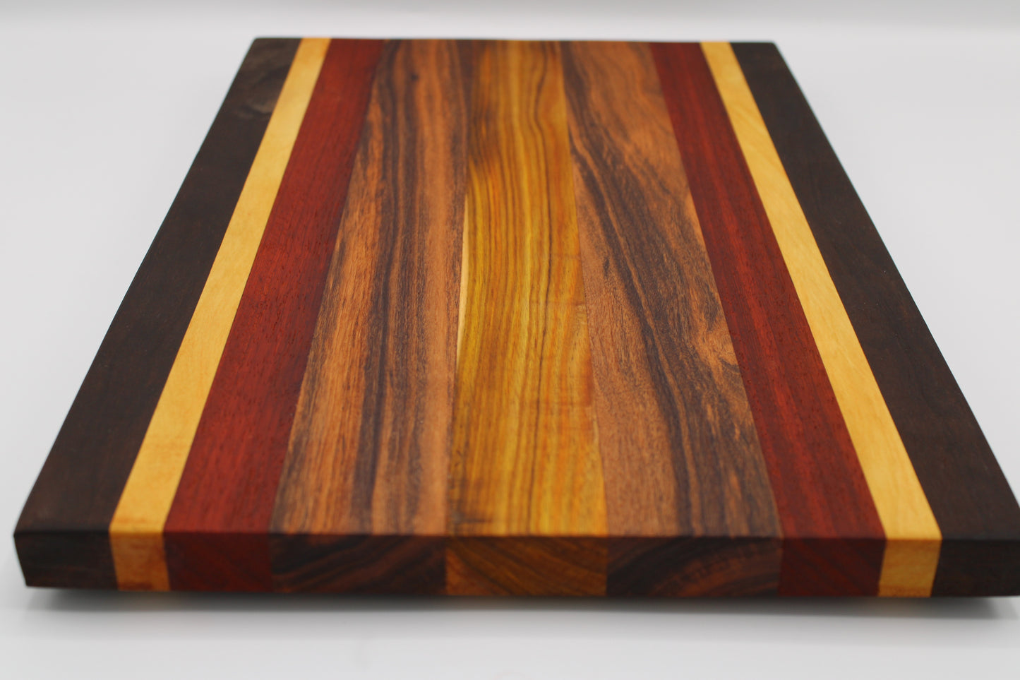 Wooden cutting board with multicolored stripes on a white background