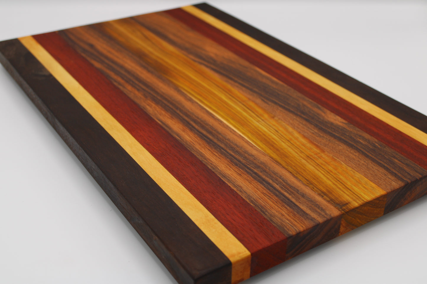 Wooden cutting board with multicolored stripes on a white background