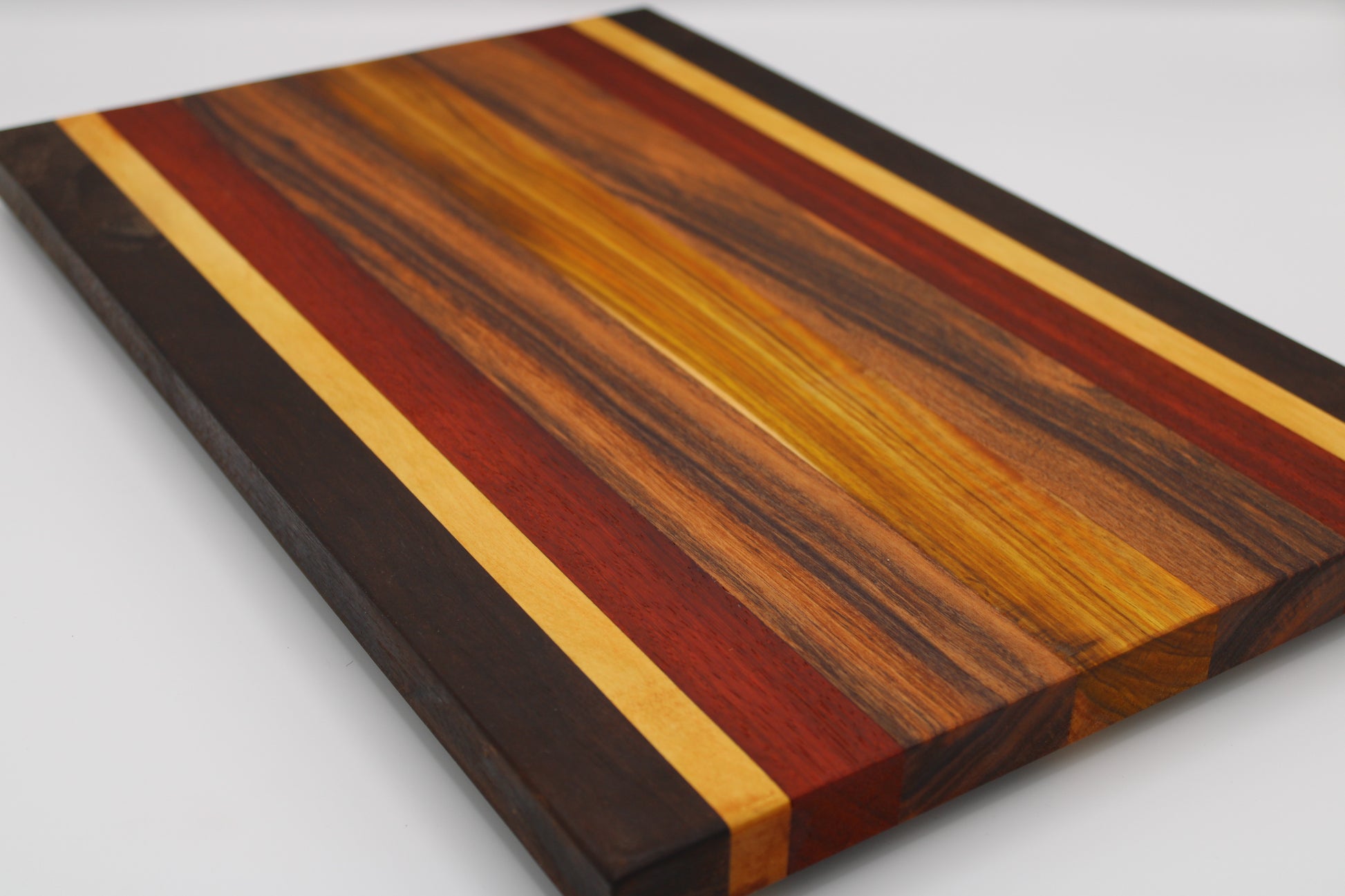 Wooden cutting board with multicolored stripes on a white background