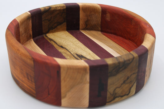 Wooden bowl with multicolored stripes on a white background