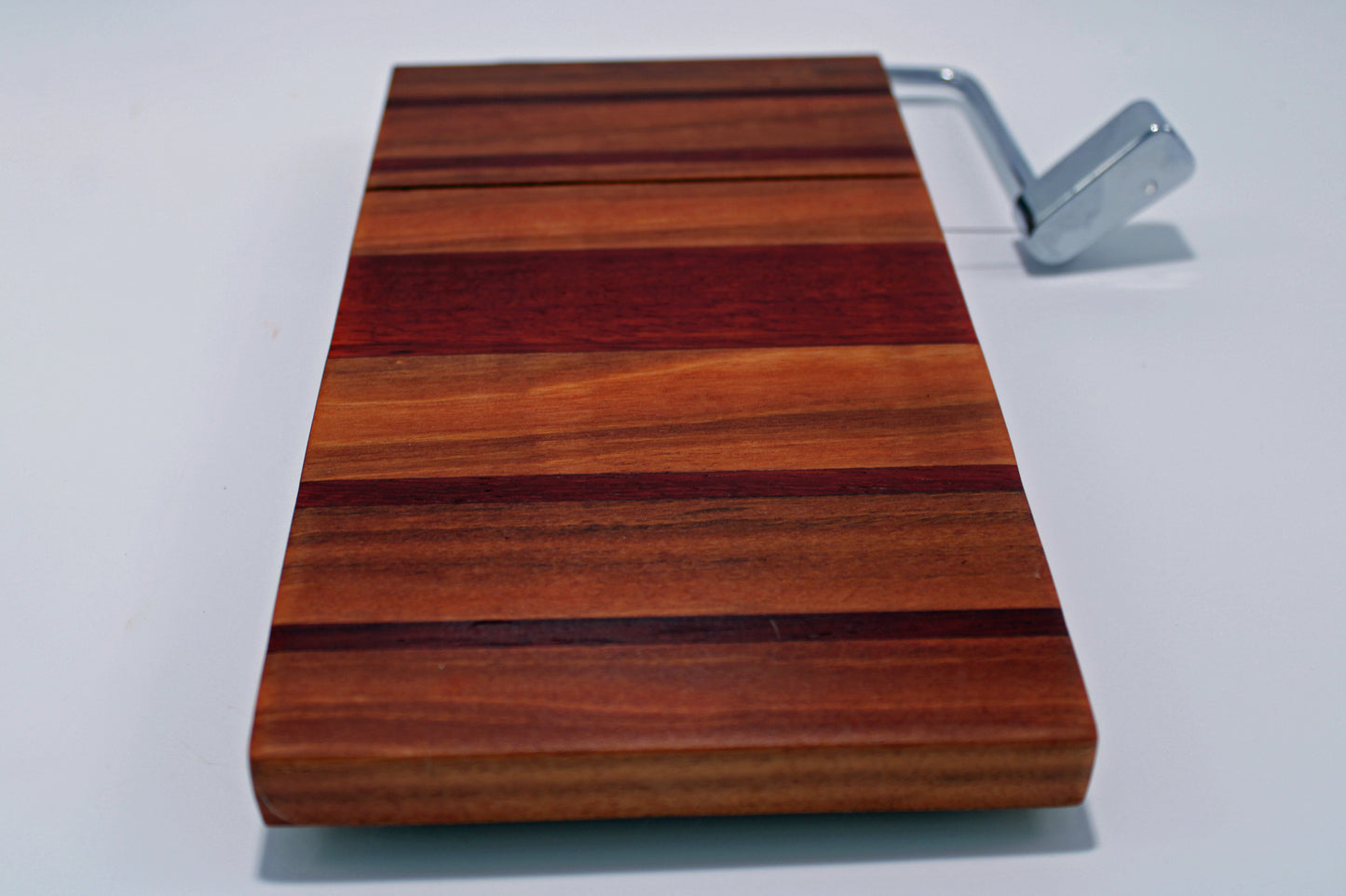 Wooden cutting board with a metal handle on a white background