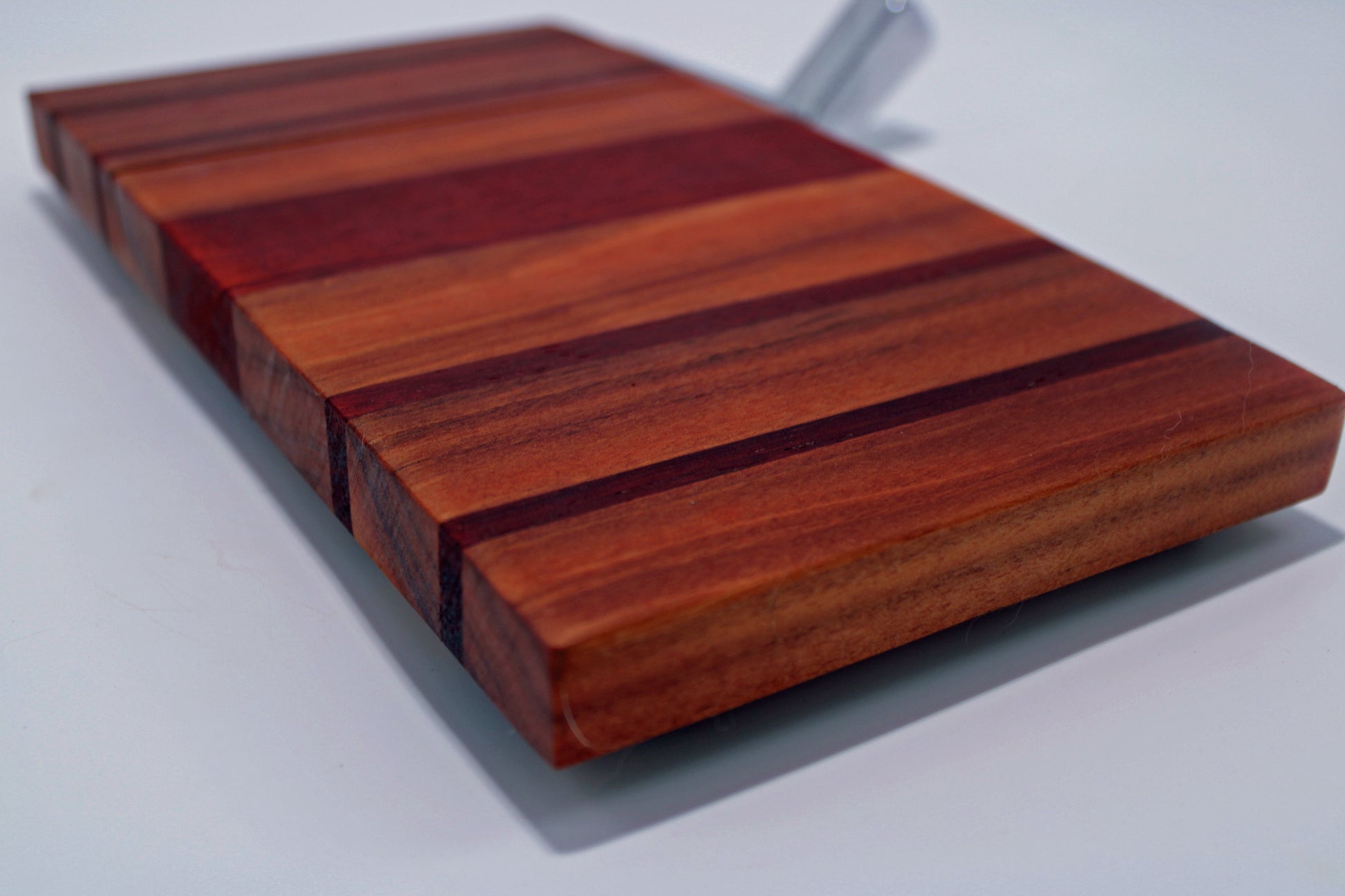 Wooden cutting board with a striped pattern on a white background