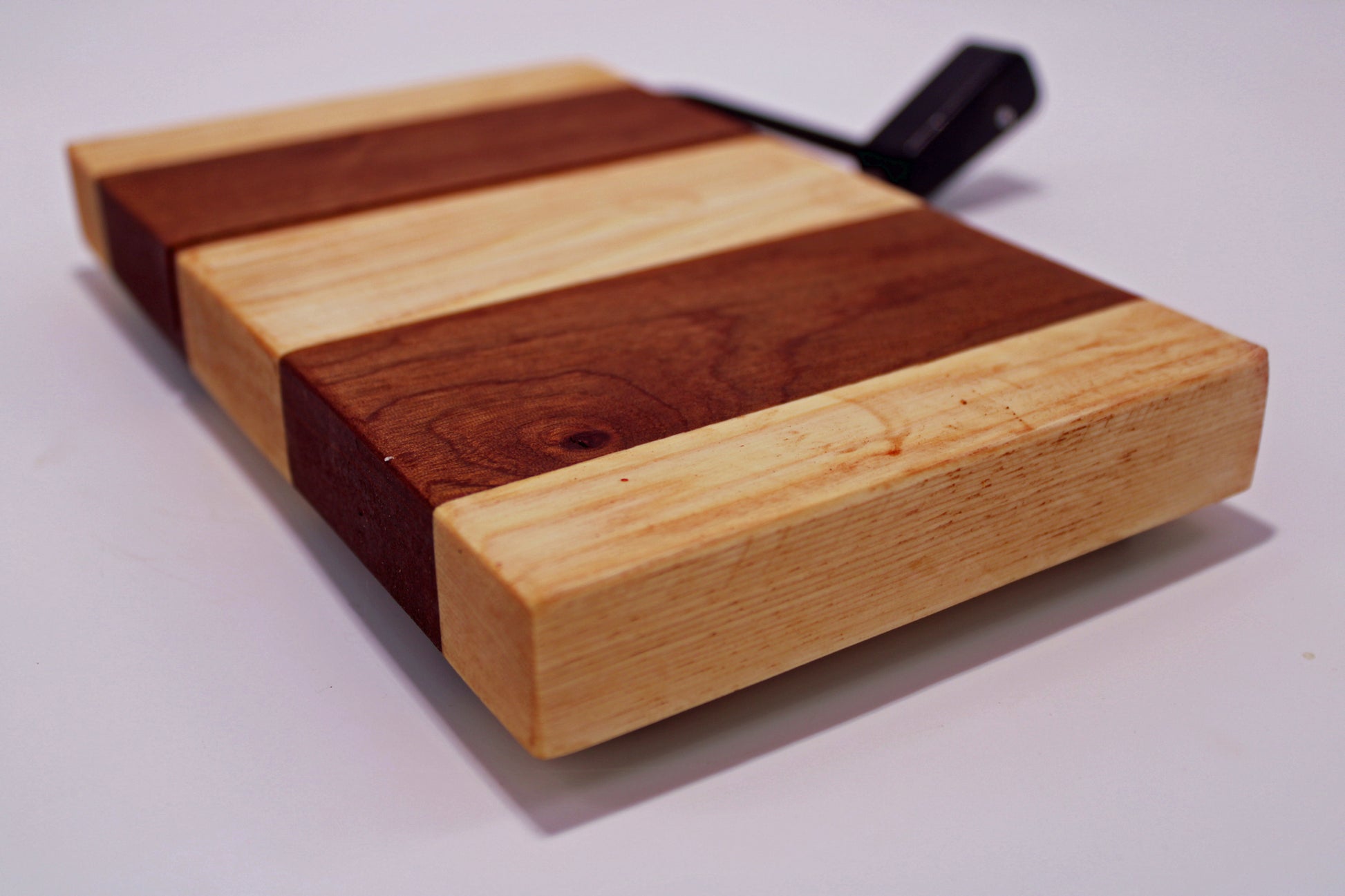 Wooden cheese cutting board with a slicer on a white background