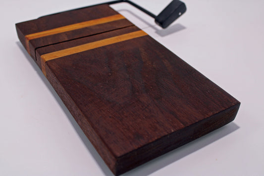 Wooden cheese cutting board with a slicer on a white background