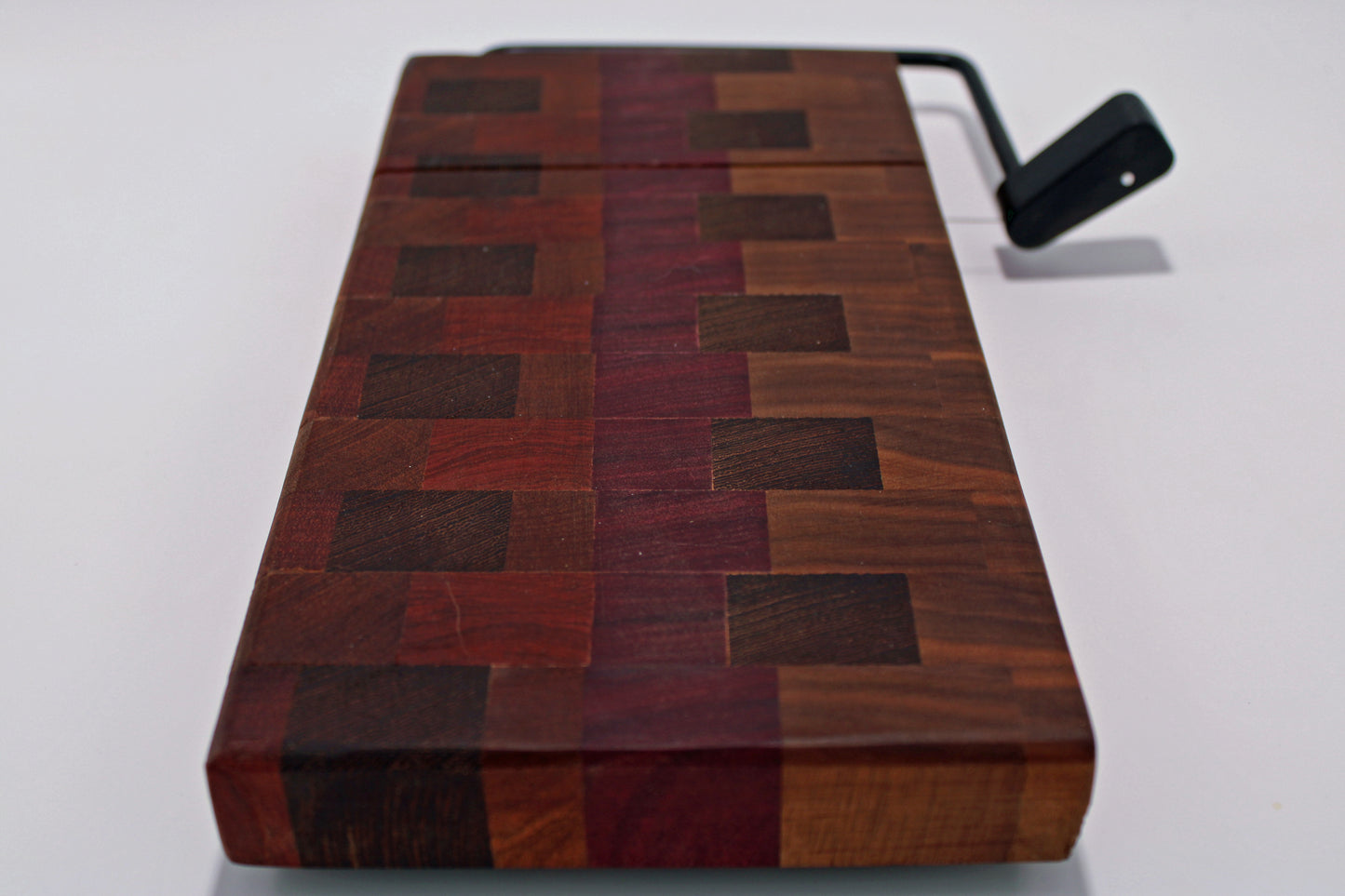 Wooden cheese cutting board with a slicer on a white background