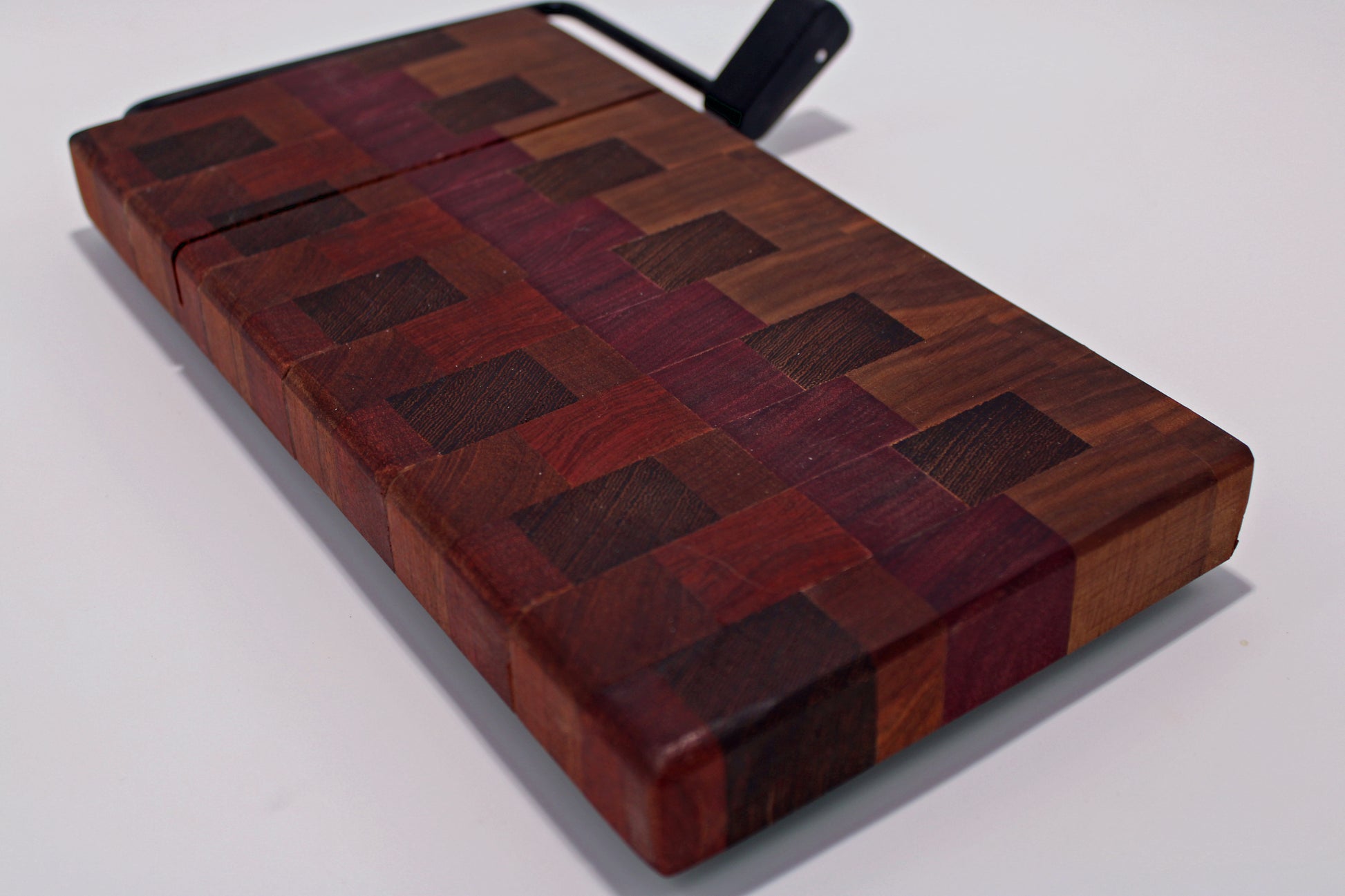 Wooden cheese cutting board with a slicer on a white background