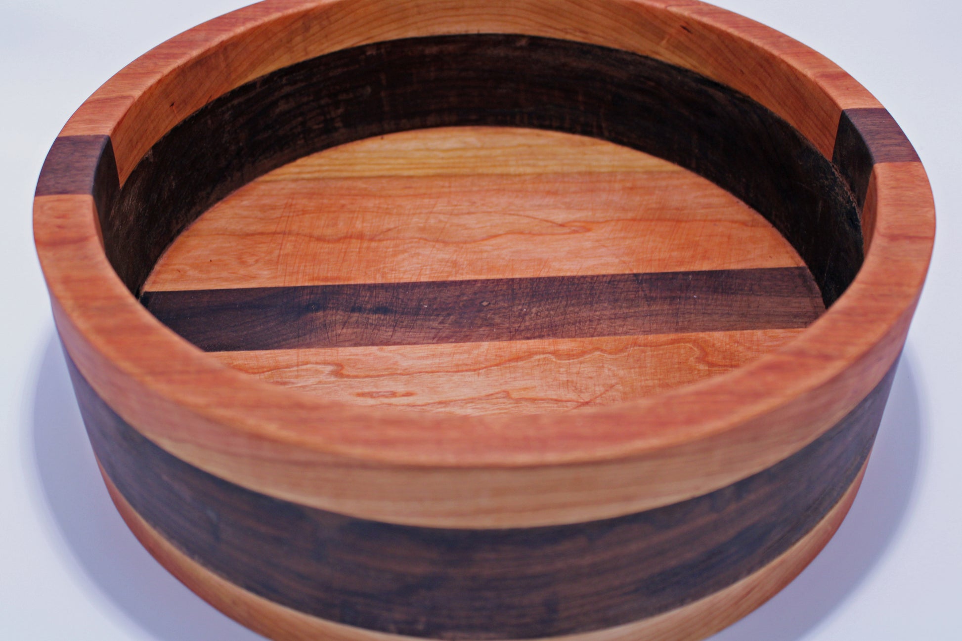 Wooden bowl with a striped pattern on a white background