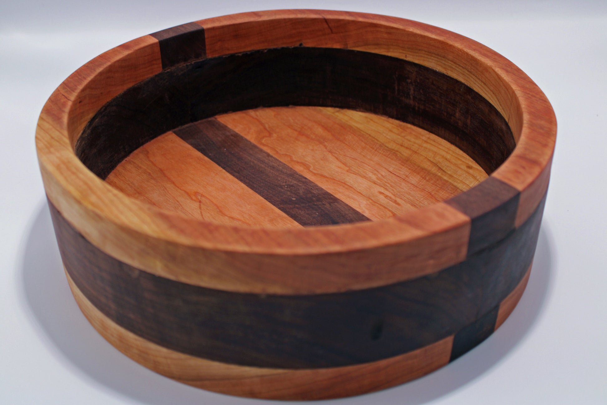 Wooden bowl with a striped pattern on a white background