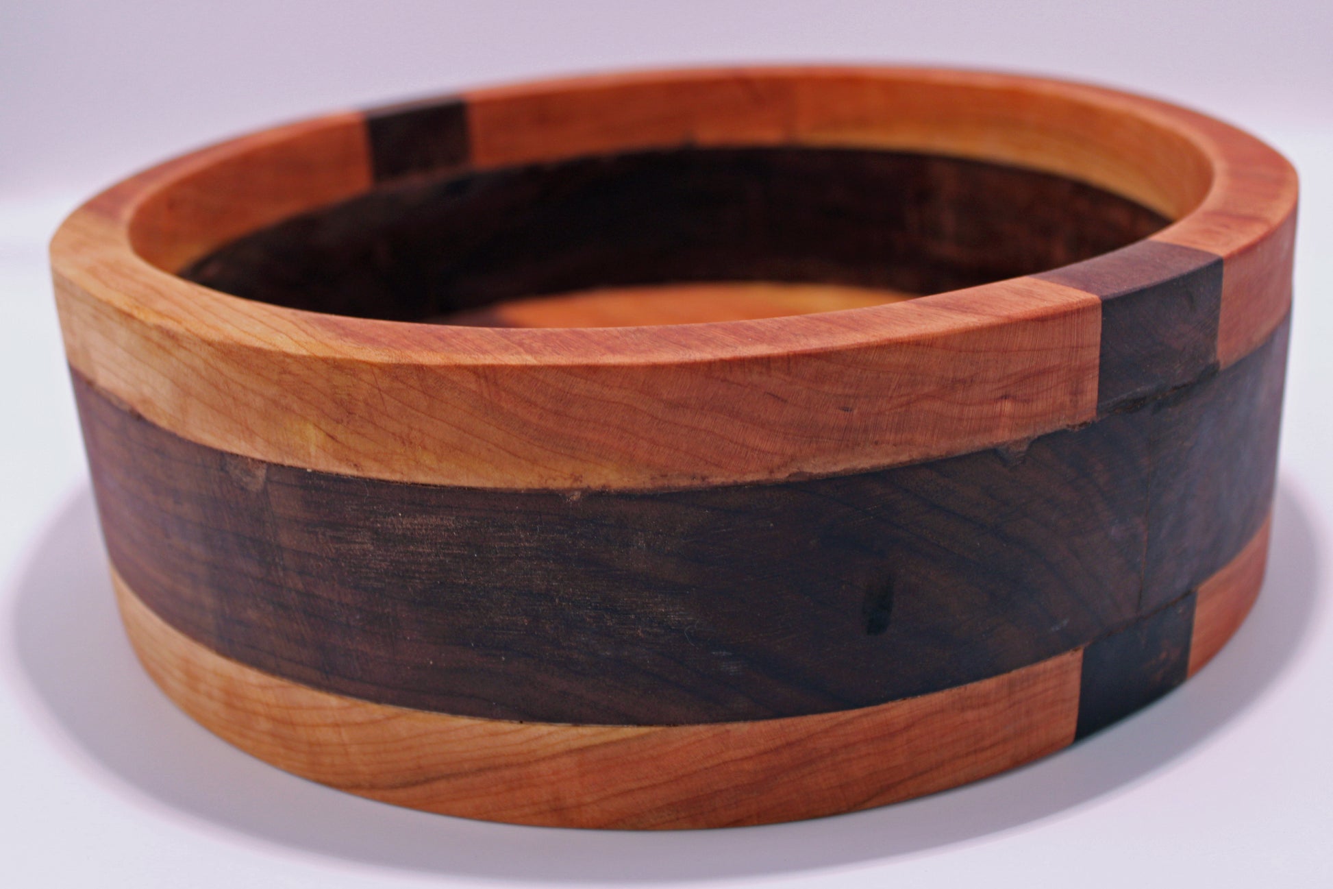 Wooden bowl with a multicolored pattern on a white background
