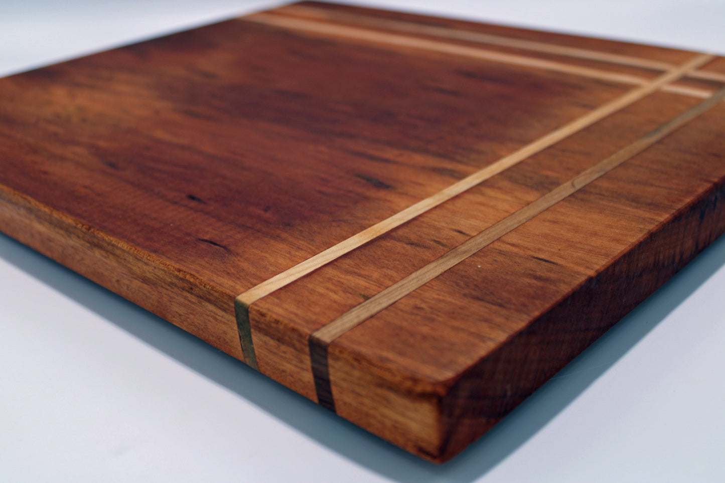 Wooden cutting board with a striped pattern on a white background