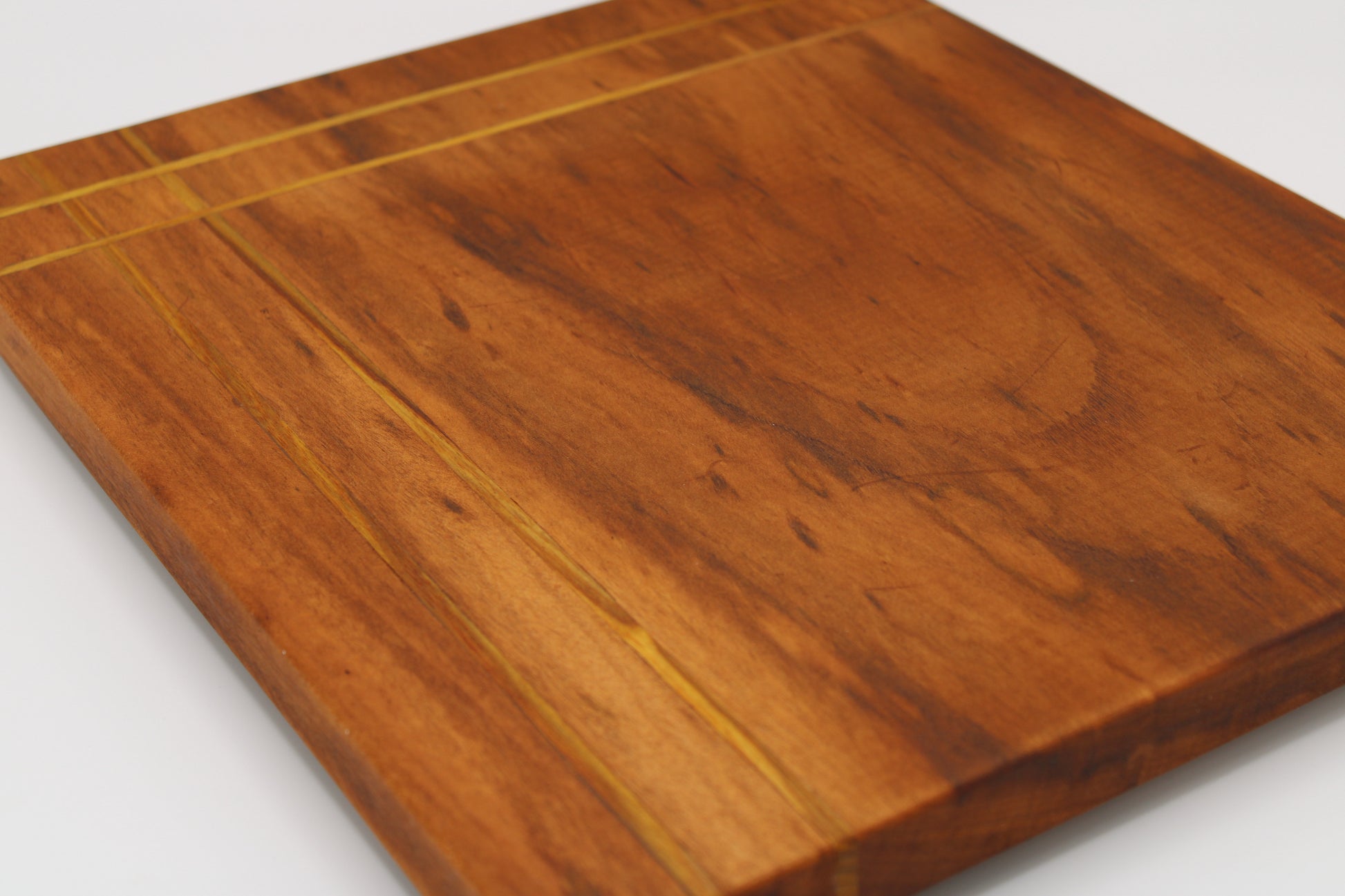 Wood cutting board with inlaid stripes
