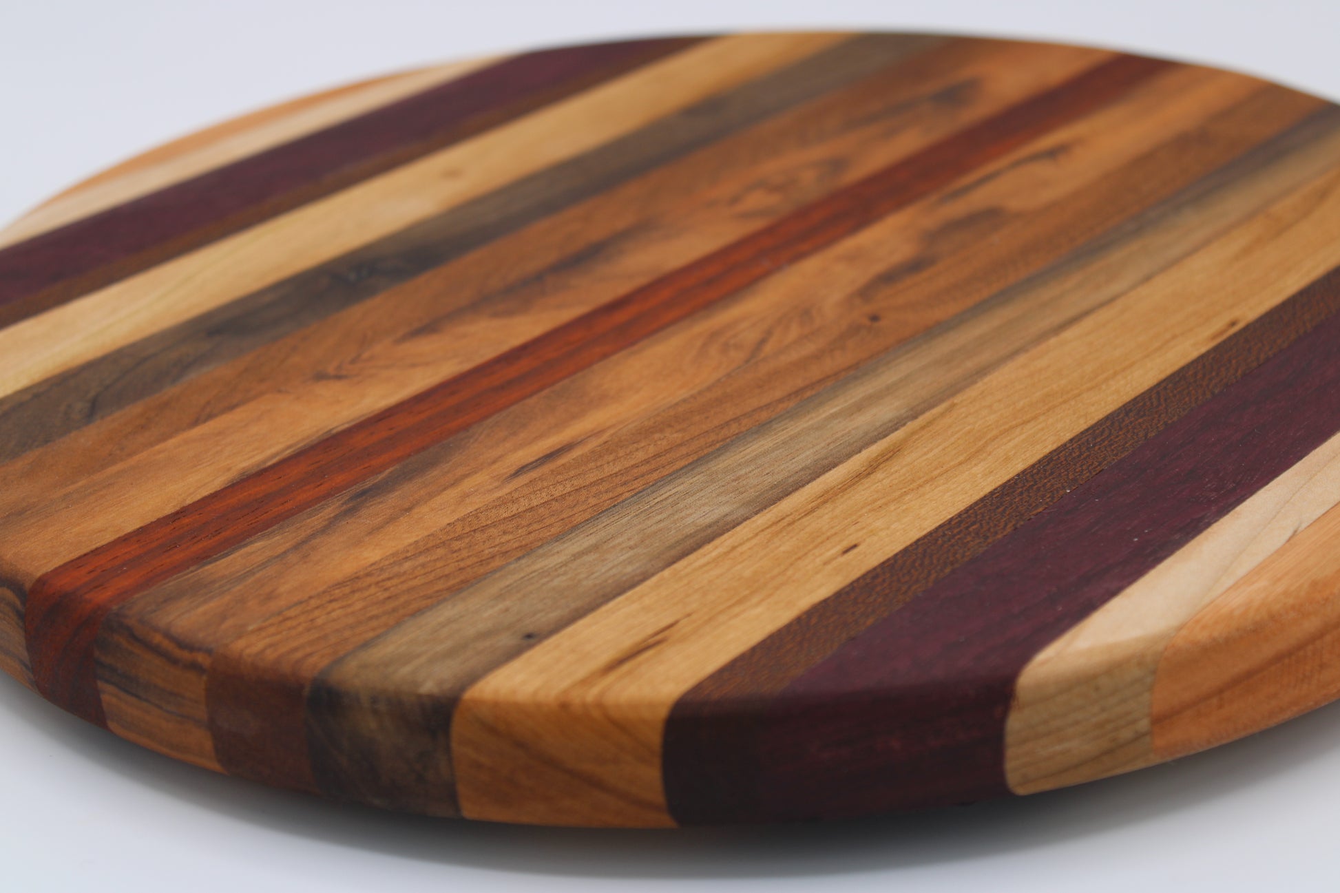 Round wood cutting board will multi color stripes