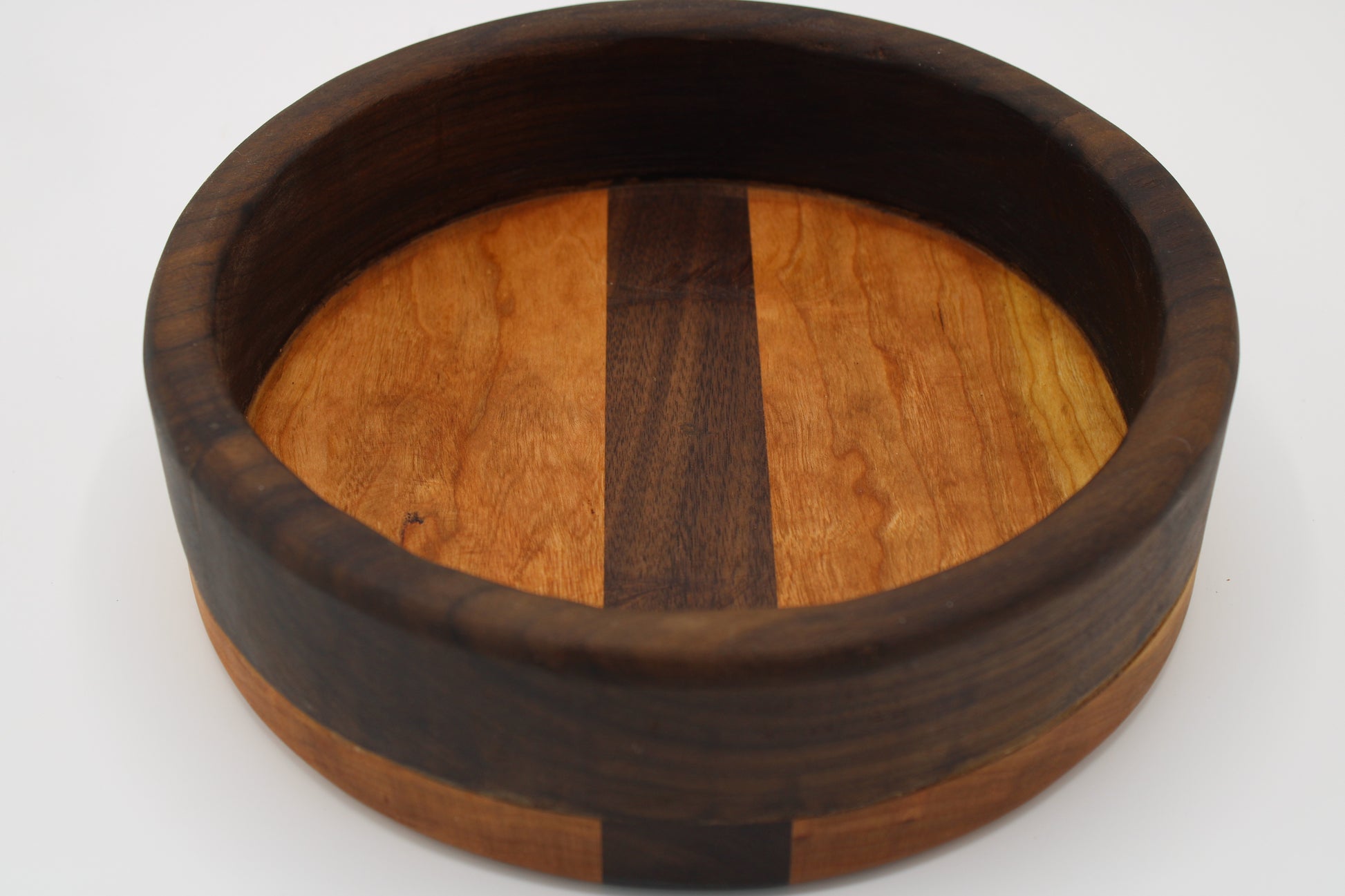 wooden bowl in dark and reddish wood on gray background