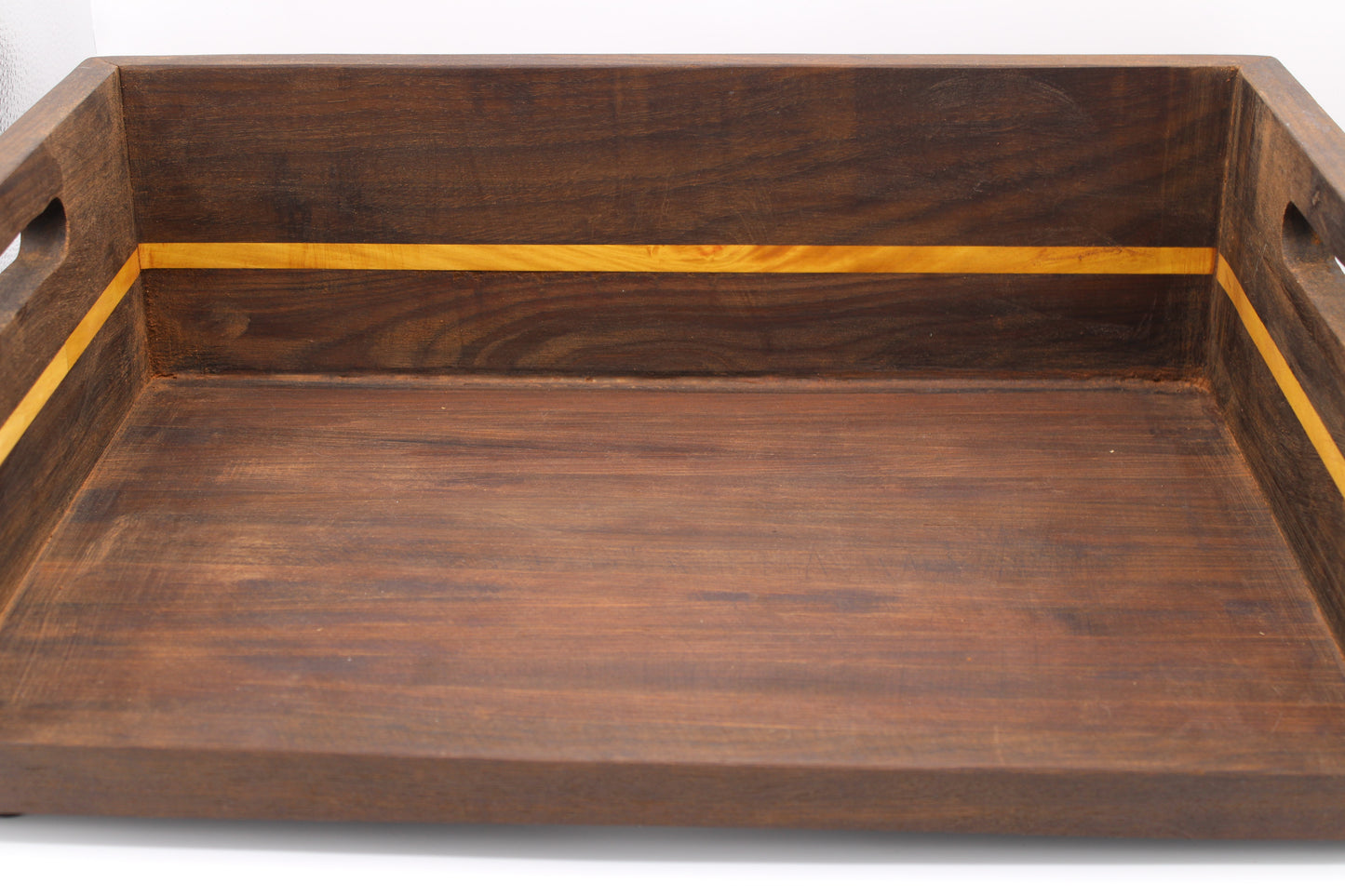 A rectangular wooden serving tray with cutout handles on the sides, featuring a dark brown wood finish and a contrasting light yellow inlay stripe along the inner rim.