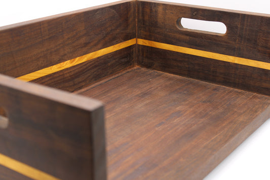 A close-up of a dark brown wooden serving tray with a lighter yellow wood accent stripe and a cutout handle on the side, shown on a white background.