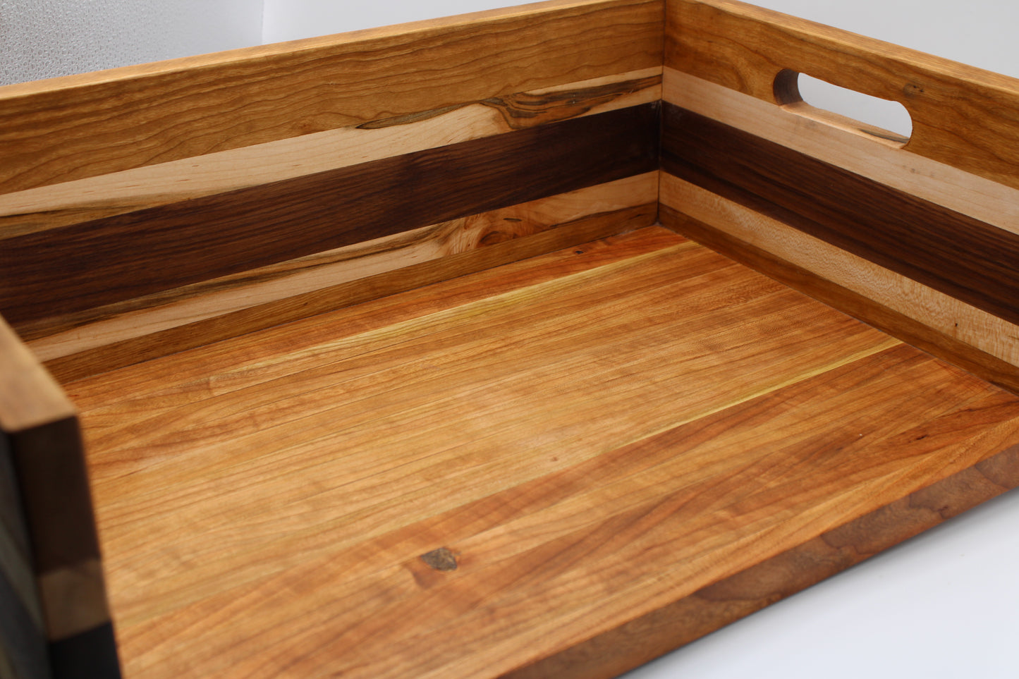 A close-up of a BBQ Chopping Box with a handle cutout, showing layered wood grain panels in light and dark tones.