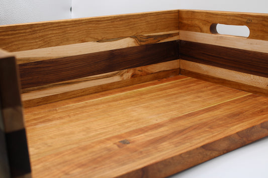 A close-up of a BBQ Chopping Box with a warm honey finish and dark wood inlay, featuring a cutout handle on the side.