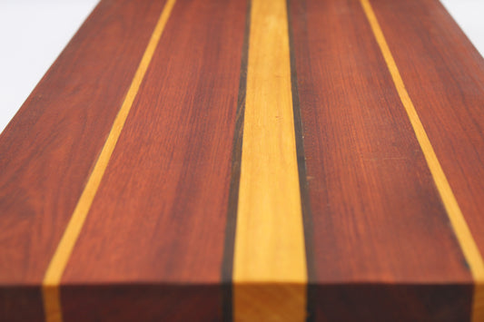 Wooden cutting board with stripes in reddish, dark brown and orange