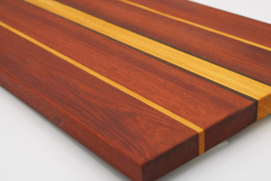 Wooden cutting board with stripes in reddish, dark brown and orange