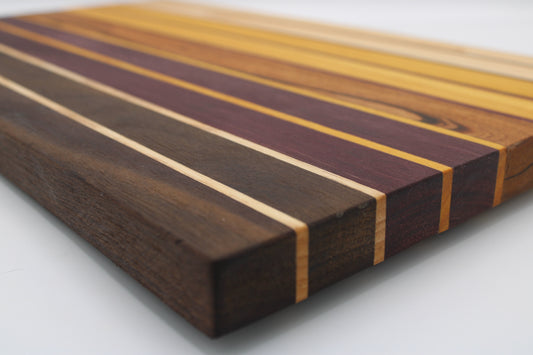 Wooden cutting board with gradient colors ranging from dark brown to purple to medium brown to yellow to light brown.