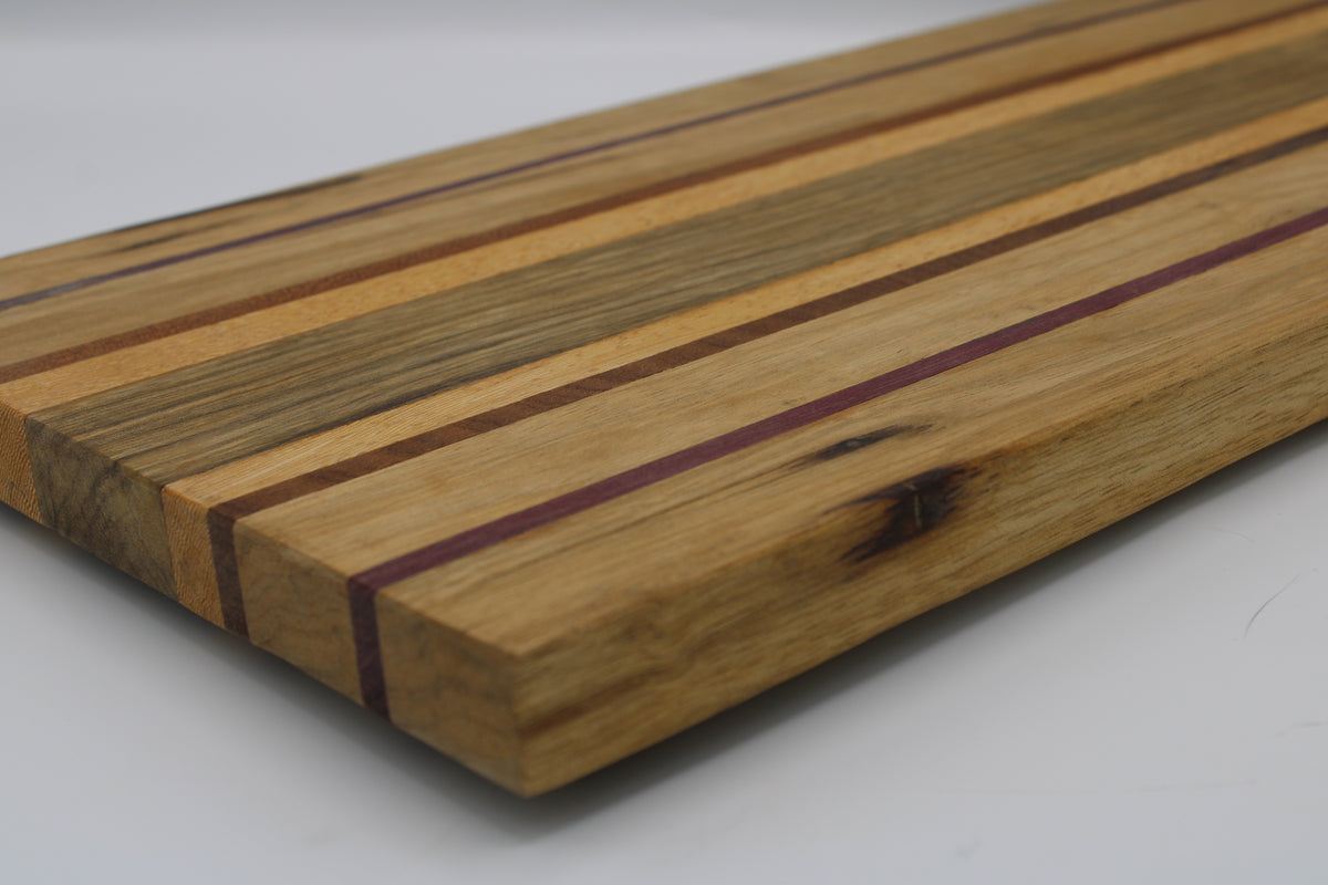 Striped cutting board in medium and light brown with purple and orange