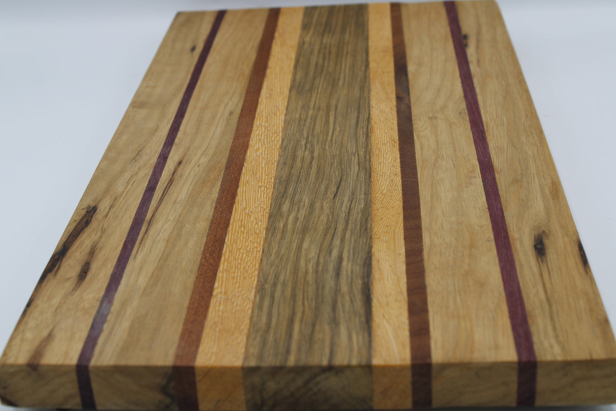 Striped cutting board in medium and light brown with purple and orange