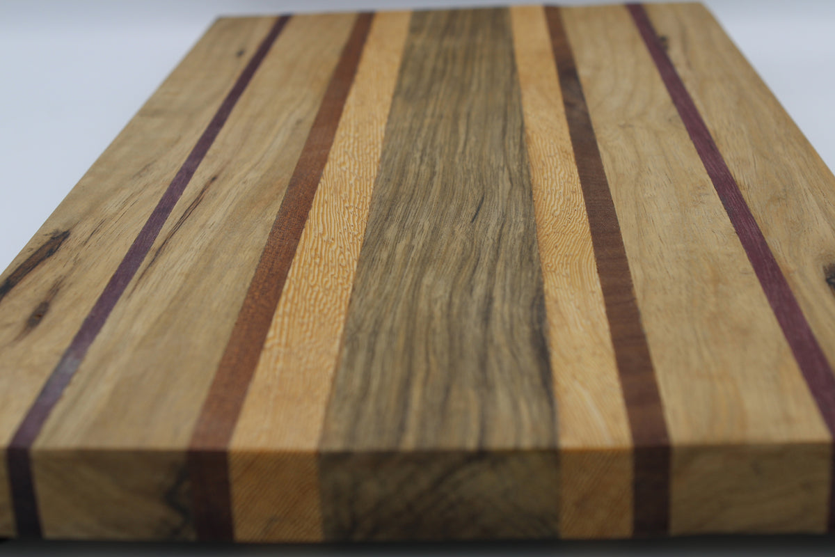 Striped cutting board in medium and light brown with purple and orange