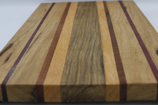 Striped cutting board in medium and light brown with purple and orange