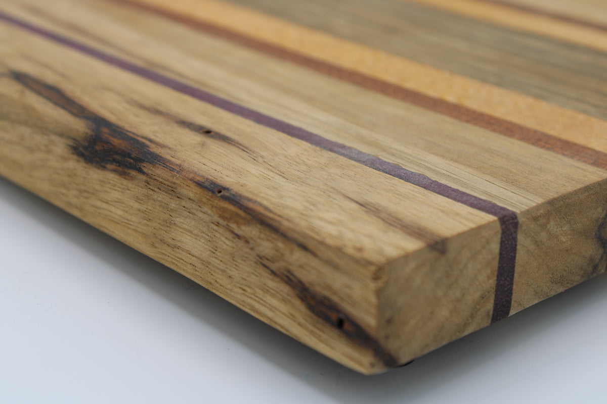 Striped cutting board in medium and light brown with purple and orange