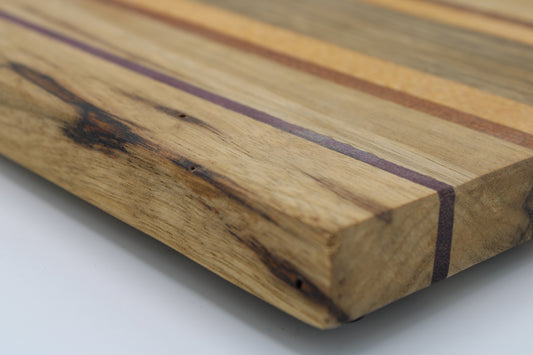 Striped cutting board in medium and light brown with purple and orange